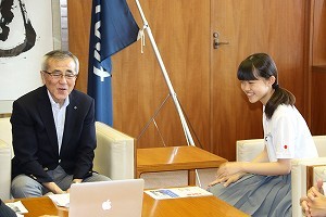 奥塚市長にニューヨークでの研修の様子を報告する松本さん