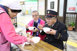 駅長と一緒に酢餅を食べている様子