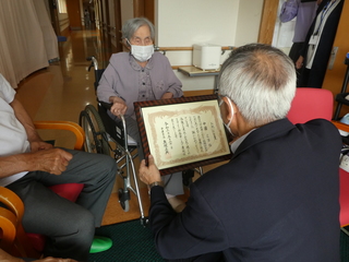 お祝い状を渡す奥塚市長