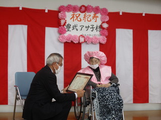 お祝い状を渡す奥塚市長