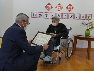 お祝い状を渡す奥塚市長