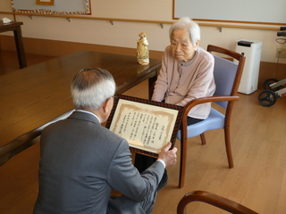 お祝い状を渡す奥塚市長